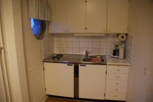 a small kitchen with white cabinets and a sink at Wellingehus Hotel in Vellinge