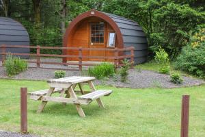 a picnic table and a yurt in a yard at Glamping Hut - By The Way Campsite in Tyndrum