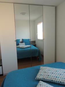 a mirror in a bedroom with a bed at Cathymini à Sete in Sète