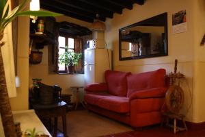 a living room with a red couch and a refrigerator at Hostería La Antigua in Potes