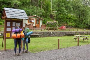 two people are standing at a bus stop at Trekker Hut in Tyndrum