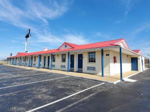 un edificio blanco con techo rojo y aparcamiento en Americas Best Value Inn Wildersville, en Wildersville