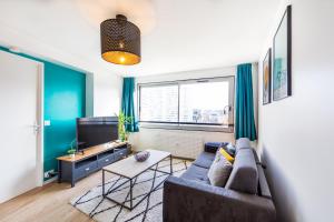 a living room with a couch and a tv at SPLENDIDE APPARTEMENT RENNES CENTRE + PARKING in Rennes
