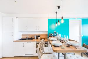 a kitchen with a wooden table and white cabinets at SPLENDIDE APPARTEMENT RENNES CENTRE + PARKING in Rennes