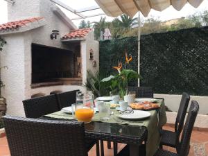 einen Tisch mit Speisen und Orangensaft auf einer Terrasse in der Unterkunft Bungalow Altea junto al casco antiguo, piscina y barbacoa in Altea