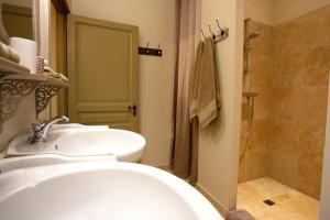 a bathroom with a sink and a tub and a shower at Les Hauts de Condom Appartements Climatises in Condom
