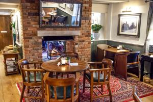 un restaurante con chimenea, mesas y sillas en The Bell - Brunning and Price, en Alderminster
