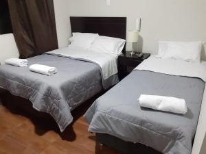 two beds in a hotel room with towels on them at ORBEGOSO - Trujillo in Trujillo