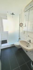 a white bathroom with a sink and a toilet at Sanosueno in Sonthofen +32 photos
