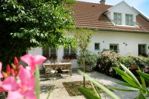 a white house with a table and chairs in a yard at Auszeit in Apetlon