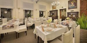 una sala da pranzo con tavoli bianchi e sedie bianche di Anette Hotel a Praga
