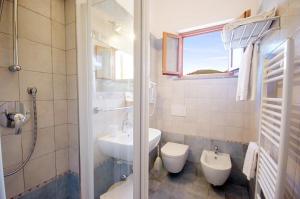 bagno bianco con lavandino e servizi igienici di Hotel Alma a Campo nell'Elba