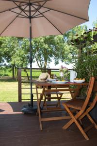 a table and chair with an umbrella on a patio at Les Hauts de Condom Appartements Climatises in Condom