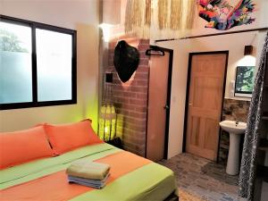 1 dormitorio con cama, ventana y lavamanos en Hostal Oloncito, en Olón
