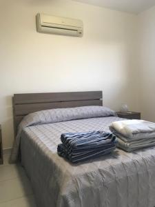 a bedroom with a bed with a air conditioner on the wall at Mazotos 54m2 One Bedroom Flat, "Panoramic Village" in Mazotos