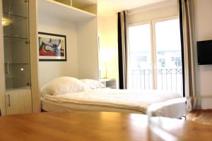 um quarto com uma cama e uma grande janela em a-partment Cologne Riverside em Colónia