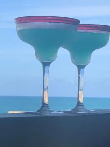 a blue drink in two glasses sitting on a table at Cupe Beach Living Beira Mar Flats Azure e Royal in Porto De Galinhas