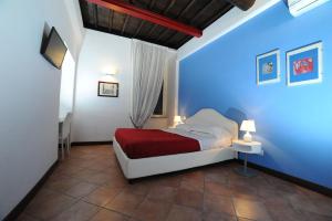 1 dormitorio con cama y pared azul en RELAIS CAVOUR 133 en Roma