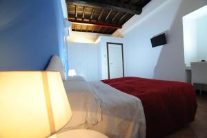 1 dormitorio con 1 cama con manta roja en RELAIS CAVOUR 133 en Roma