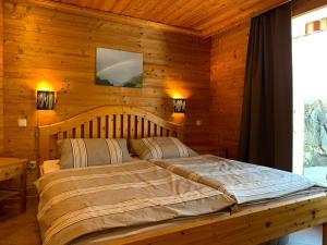 ザンクト・ニクラウスにあるChalet Victoriaの木製の部屋にベッド1台が備わるベッドルーム1室があります。