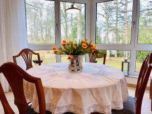 een eettafel met een vaas met bloemen erop bij Villa Seepark App .4 in Heringsdorf