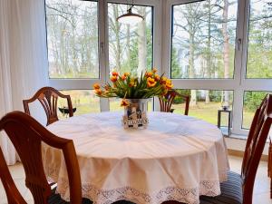 uma mesa de jantar com um vaso de flores em Villa Seepark App .4 em Heringsdorf