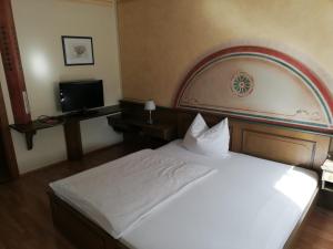 una camera da letto con un grande letto bianco e una televisione di Gasthof Kogler-Greisinger a Frankenmarkt