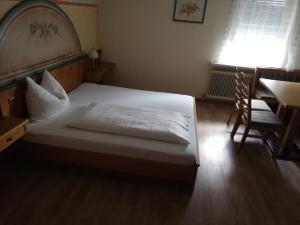 una camera da letto con un letto, una scrivania e una sedia di Gasthof Kogler-Greisinger a Frankenmarkt