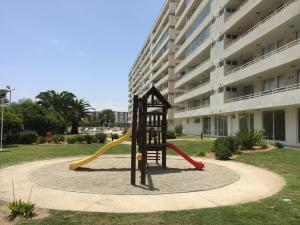 a playground in front of a building with a slide at Apartamento Terrazas del Sol in La Serena