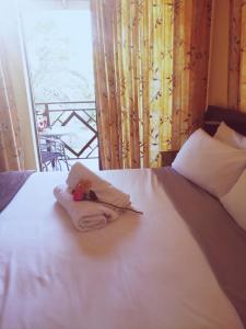 een wit bed met een handdoek en een mes erop bij Hilton Gardens Guesthouse in Richards Bay