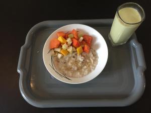 un piatto di farina d'avena con frutta e un bicchiere di latte di RoaBaa Guesthouse a Batticaloa