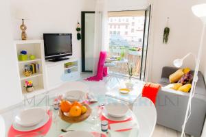 a living room with a glass table and a tv at 4Seasons La Rosaleda Apartment in Málaga