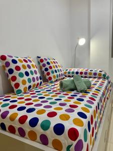 a bed with polka dot sheets and two pillows at Samsara Beach in Port d'Alcudia