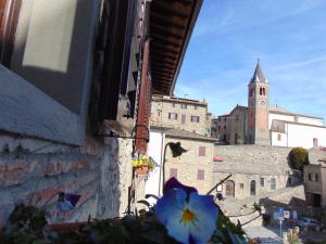 een uitzicht op de stad vanuit een raam met een blauwe bloem bij Fra I Mesi in Ambra