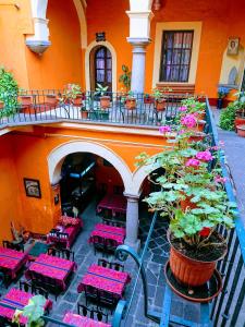 an outdoor patio with red tables and chairs and flowers at Suite Vintage in Puebla