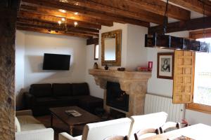 a living room with a couch and a fireplace at Santamaría - Mirador de Pedraza in Pedraza-Segovia