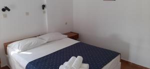 een slaapkamer met een bed met witte handdoeken bij Level Houses in Kefalos