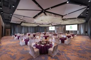 a large banquet hall with tables and white chairs at Holiday Inn Hangzhou Airport Zone, an IHG Hotel in Xiaoshan