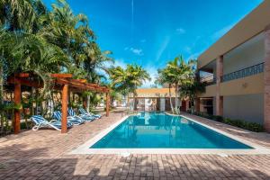a villa with a swimming pool and palm trees at Tecnohotel Itzáes in Mérida