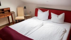 ein weißes Bett mit einem roten Kopfteil und weißen Kissen in der Unterkunft Villa ZOE Sankt Wendel in Sankt Wendel