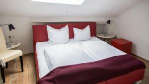 een slaapkamer met een rood-wit bed en een stoel bij Villa ZOE Sankt Wendel in Sankt Wendel