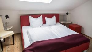 ザンクト・ヴェンデルにあるVilla ZOE Sankt Wendelのベッドルーム(赤と白のベッド1台、椅子付)