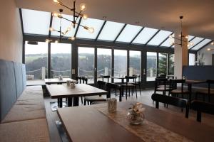 a restaurant with tables and chairs and large windows at Landhotel Donaublick in Obernzell