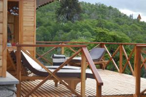 a wooden deck with a chair and a table at Parajes del lejano sur cabaña El Cardo in Moquehue