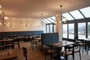 a restaurant with tables and chairs and windows at Landhotel Donaublick in Obernzell