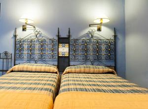 1 dormitorio con 2 camas y 2 luces en la pared en Casa Sastre Segui, en Patró