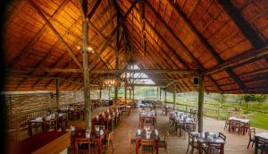 a dining room with tables and chairs in a building at Shearwater's Explorers Village in Victoria Falls