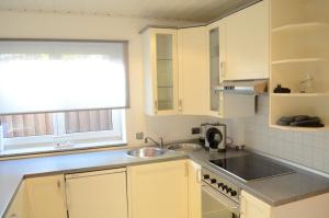 a kitchen with white cabinets and a sink and a window at Wohnung Ahorn in Riedstadt