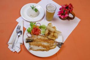 une assiette de nourriture avec du poisson, des frites et une boisson dans l'établissement Estancia, CABAÑAS INTAG, à Vacas Galindo