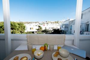 a table with plates of food on a balcony at Villa Loom Mykonos Town in Mikonos